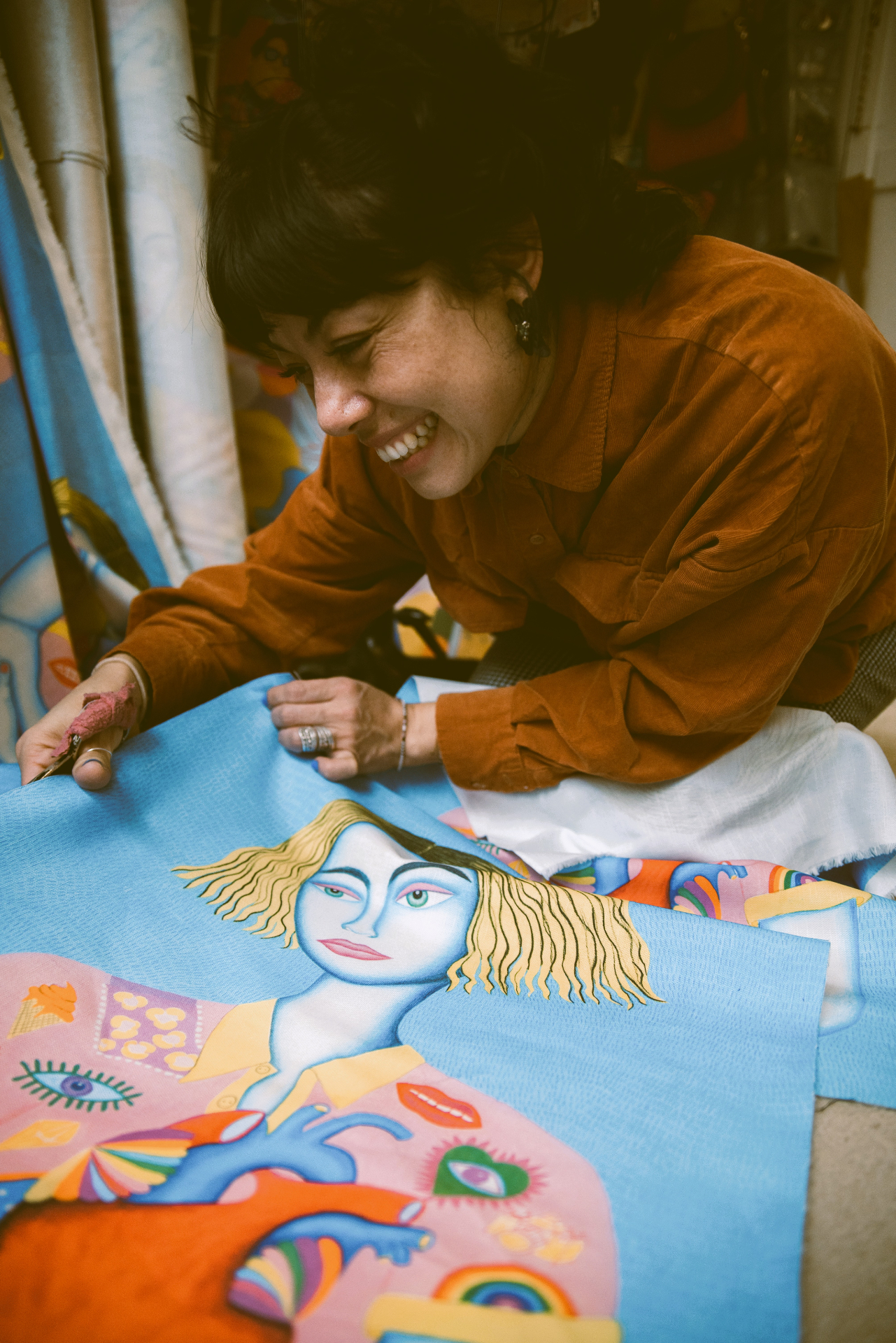 Belen cutting a printed textile featuring an illustrated character